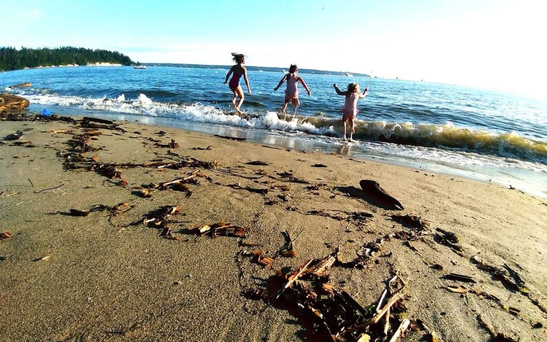 Children running into the waves on a sandy beach