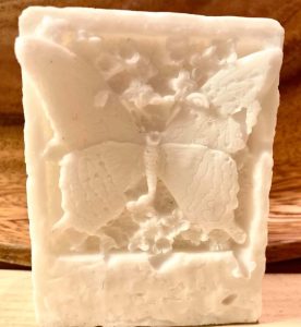White magnesium soap bar with an embossed butterfly and floral design