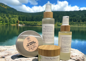 Mila Earth magnesium sprays and body butter on a rock by a mountain lake